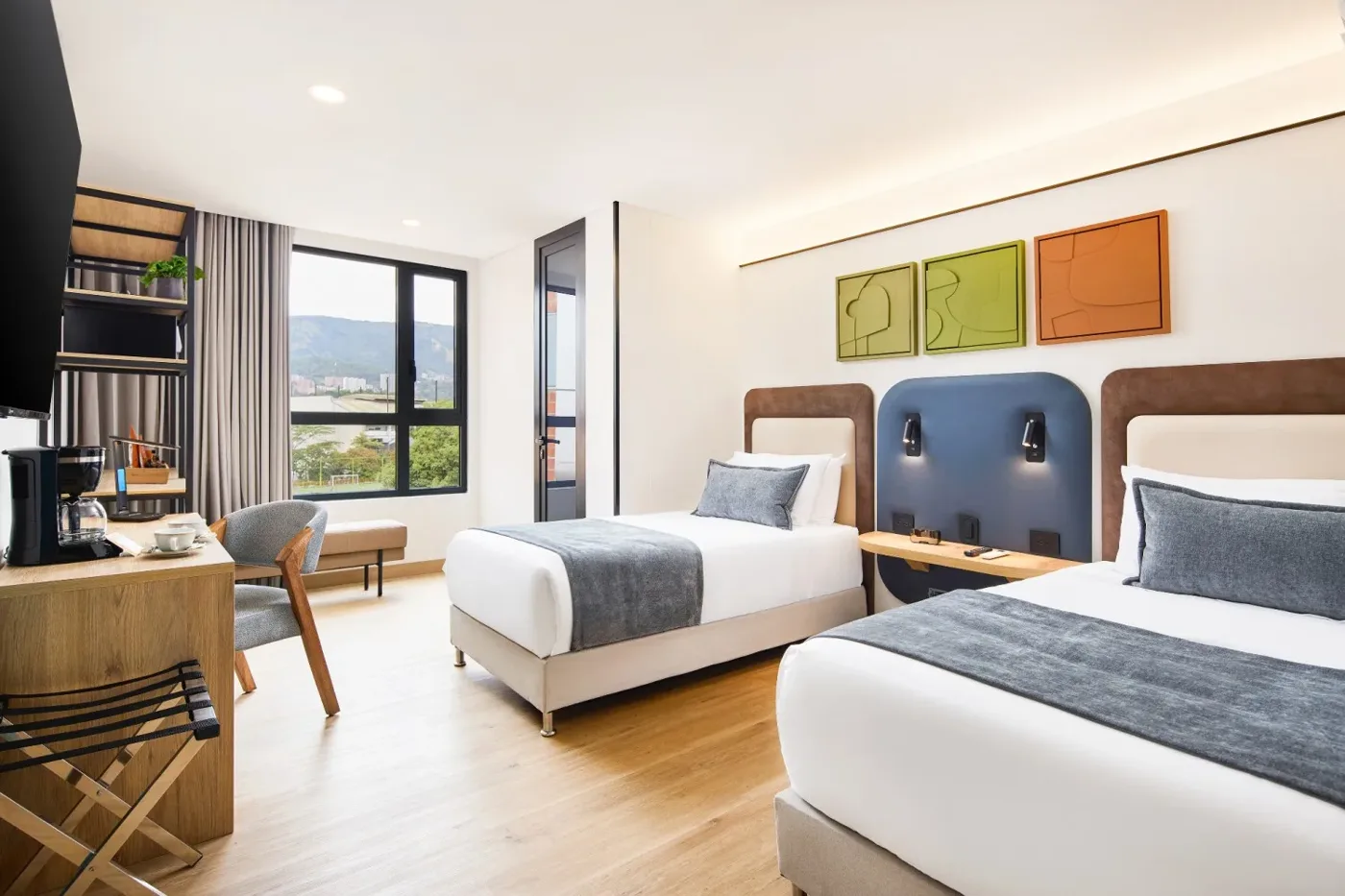 Suite Twin con dos camas, escritorio y vista a la ciudad